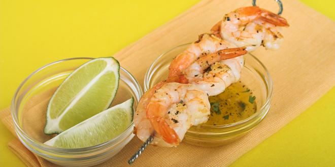 shrimp on the skewer with limes and a butter sauce